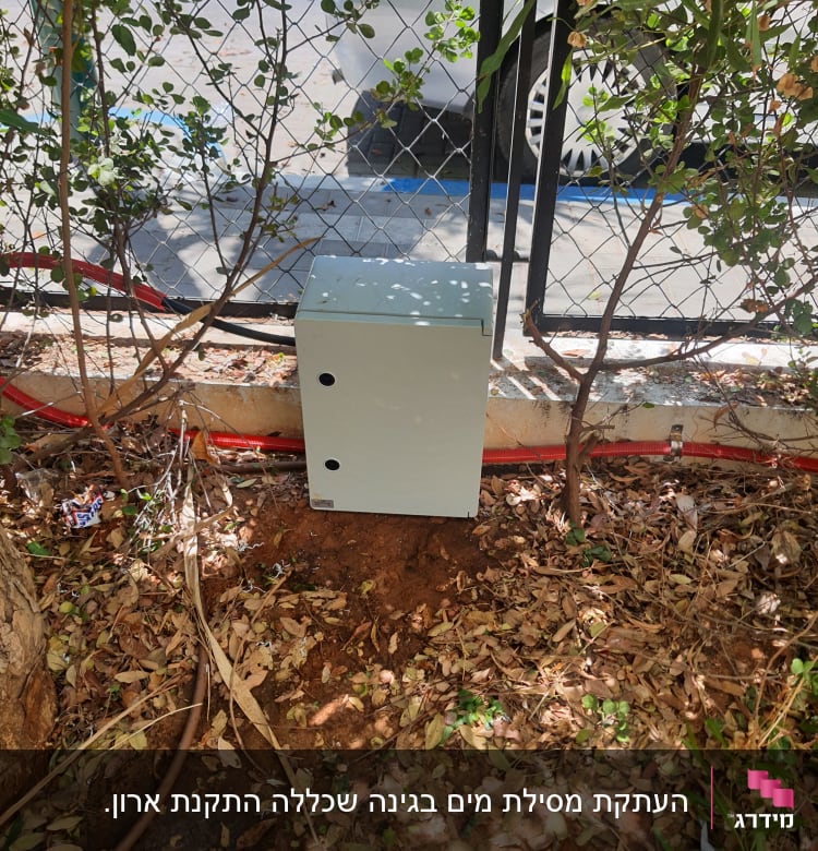 צינור חום על הקרקע ליד קופסה אפורה